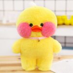 Peluche canard kawaii jaune debout sur une table en bois