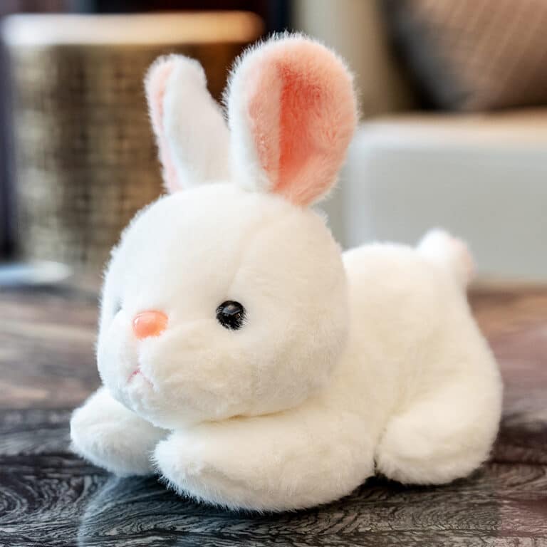 Une peluche lapin blanc mignonne sur un plan de travail.