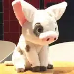Peluche cochon viana assise sur table en bois