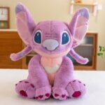 Peluche stitch rose sur un plan de travail en blanc.