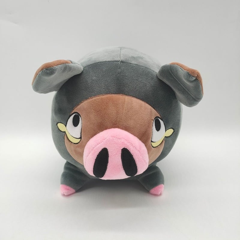 Une peluche Pokémon grise devant un arrière plan gris clair.