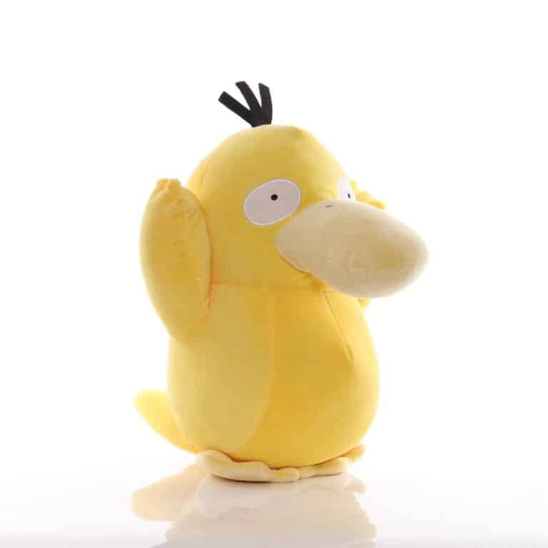 Peluche psykokwak jaune assise devant un arrière plan blanc.