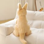 Peluche kangourou jaune kawaii sur un canapé blanc.