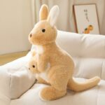 Peluche kangourou jaune kawaii sur un canapé blanc.