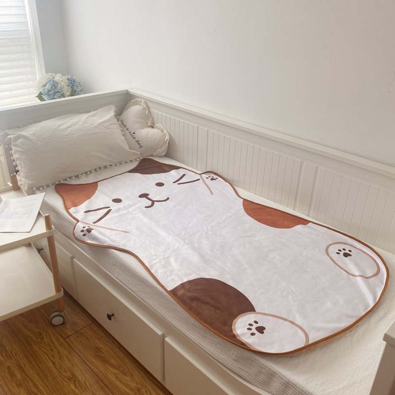 Chat en Peluche couverture flanelle blanche sur un lit