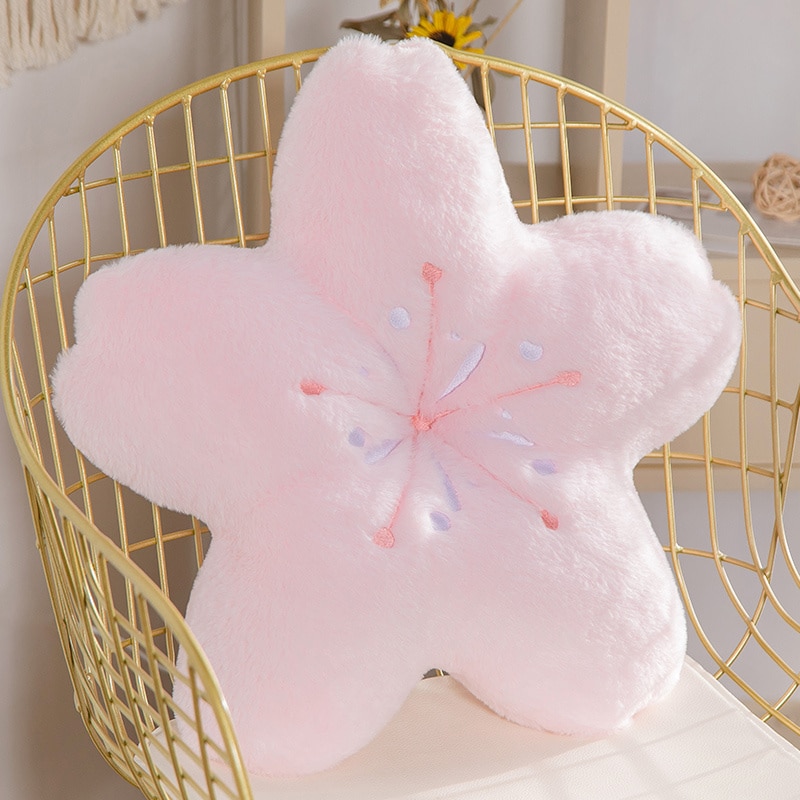 Peluche fleur rose confortable sur une chaise.