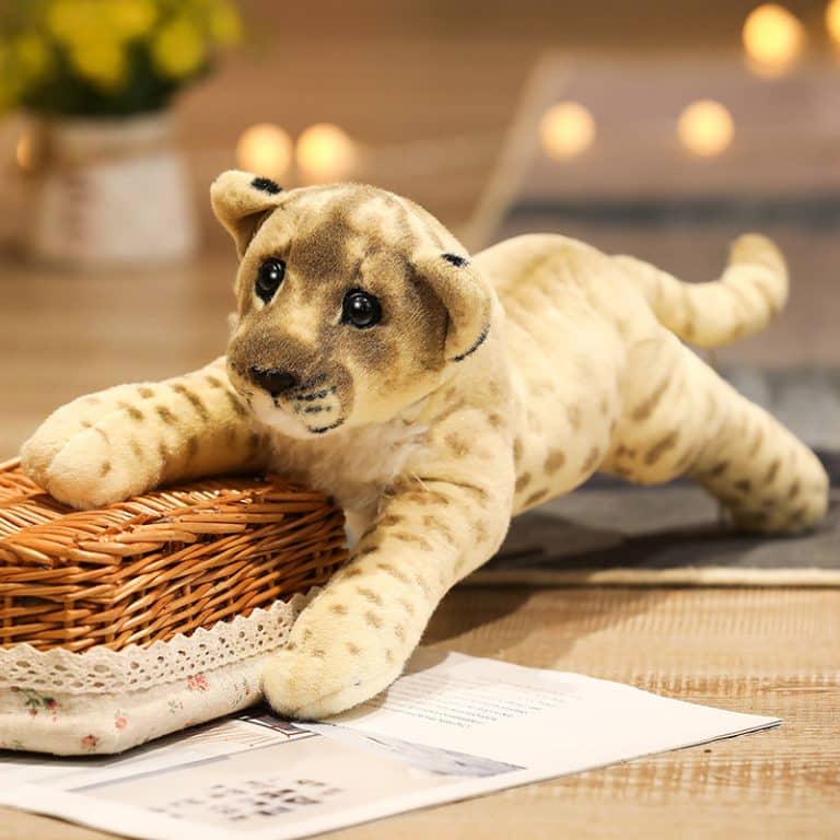Peluche XXL lion réaliste avec un pied sur un panier